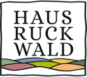 Quadratisches Logo mit schwarzer, welliger Umrandung, bunte Darstellung der sieben Hügel und Wortlaut Hausruckwald